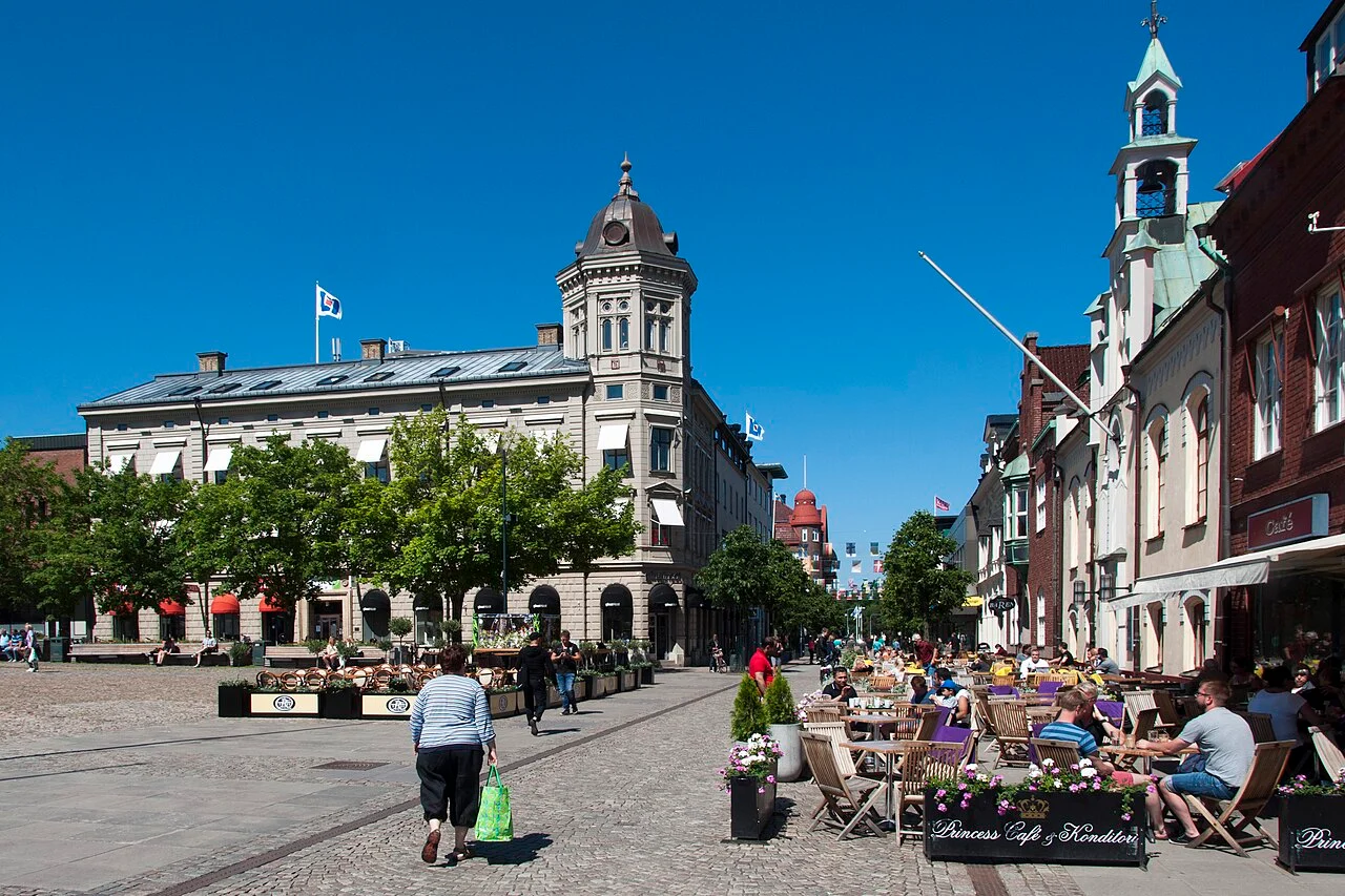 Torget i Skövde med stenhus, kyrktorn och uteserveringar.